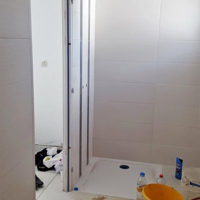 Douche carrelée blanche avec porte